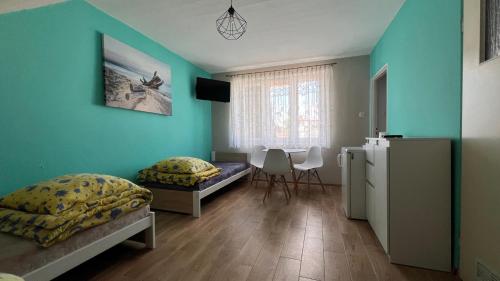 a bedroom with two beds and a table in it at Kapitańska Przystań in Chłopy