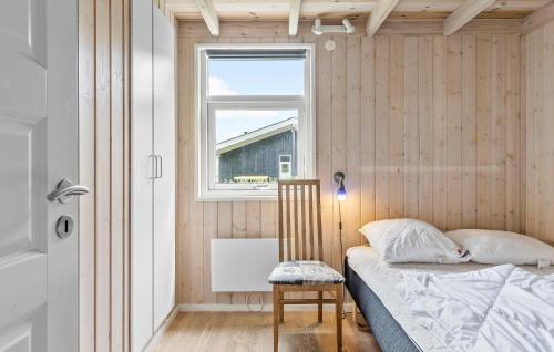 a bedroom with a bed and a window and a chair at Beautiful Home In Juelsminde With Sauna in Sønderby
