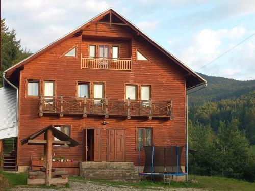 a wooden house with a balcony on top of it at Villa Gold in Yaremche