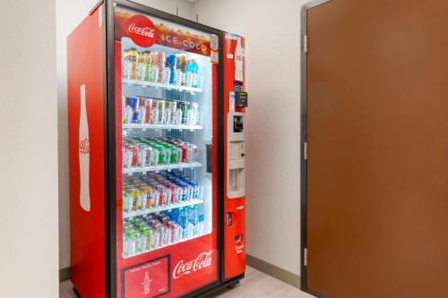 a cocacola soda machine in a room at HomeTowne Studios by Red Roof Tampa - Airport in Tampa