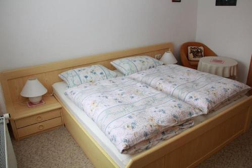 a bed with a wooden frame and two pillows on it at Haus Rita in Thurmansbang