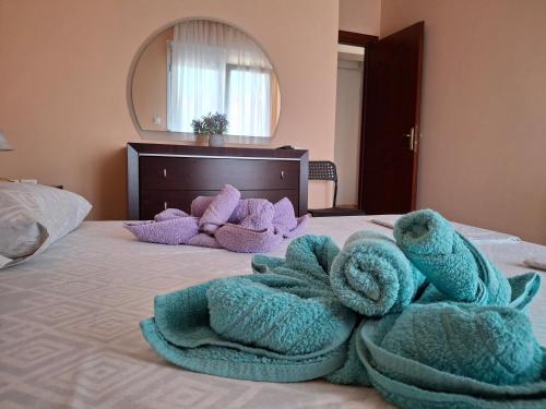 a bed with a pile of towels on it at Aurora - Close to Macedonia Airport in Kardiá
