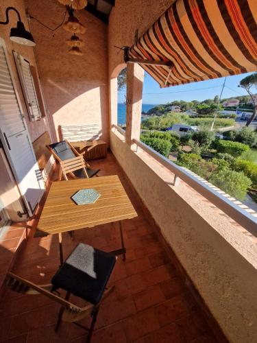 une table et des chaises sur un balcon avec vue sur l'océan dans l'établissement Studio Le miroir de la mer, à Saint-Aygulf