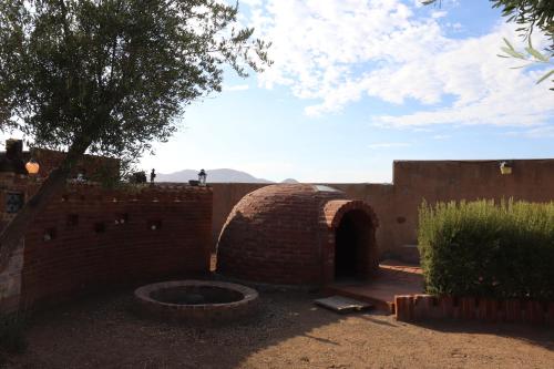 a brick wall with a brick oven in a yard at Estancia Los Amigos Valle de Guadalupe in Valle de Guadalupe