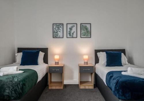 two beds in a room with two lamps on them at Modern & Stunning 4 Bedroom House in Goole in Goole