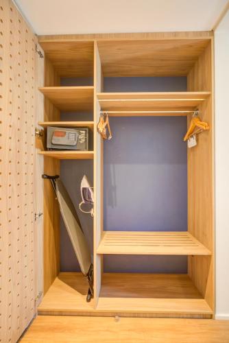 a closet with wooden shelves and a surfboard in it at Hampton by Hilton Guarulhos Airport in Guarulhos