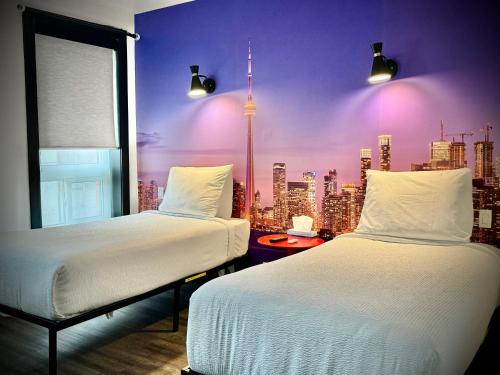 two beds in a room with a view of a city at Royal Oak Inn in Toronto