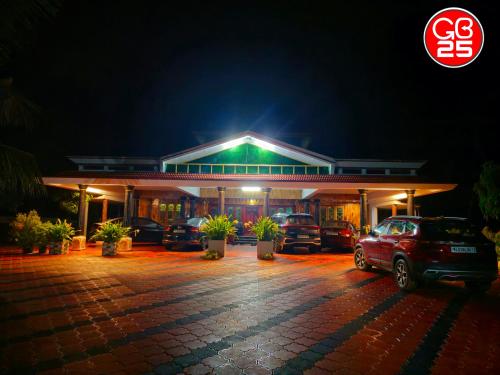 a building with cars parked in a parking lot at night at GB25 inn in Trivandrum