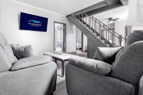 a living room with two couches and a staircase at Comfortable 5BR 2BA near the falls in Niagara Falls
