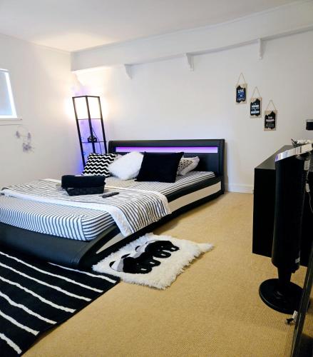 a bedroom with a bed with a black and white comforter at Comfy Stylish Room in the Heart of Vancouver- Private Parking, Self Check-in & just 4 mins to Metrotown! in Vancouver