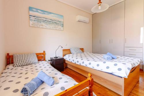 two twin beds in a room with at Modern Condo at the Beach in Sounio