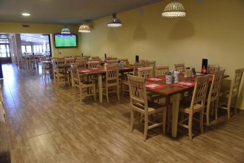 a dining room with tables and chairs in a restaurant at aQuarium Panzió in Abádszalók