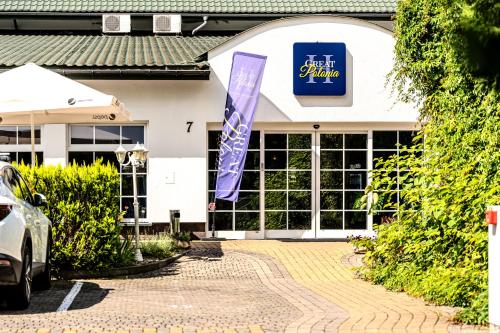 a building with a purple sign on the front of it at Great Polonia Sand Beach Mielno in Mielno