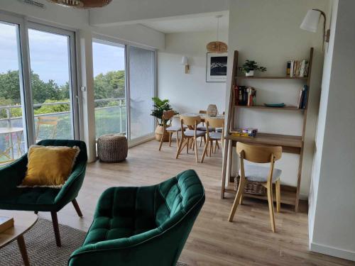 - un salon avec un canapé vert, une table et des chaises dans l'établissement La 154 - Second Souffle - Cherbourg, à Cherbourg en Cotentin
