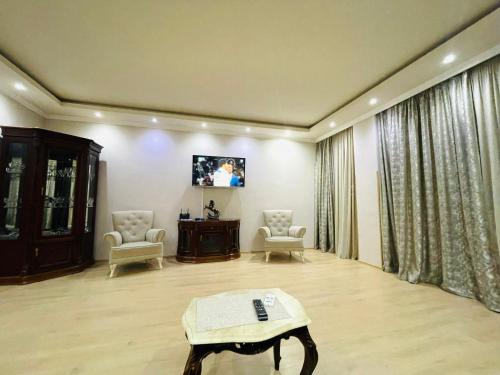 a living room with two chairs and a table at ბინა131 in Tbilisi City