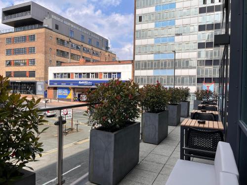 a row of benches and potted plants on a city street at B&B HOTEL Birmingham Centre in Birmingham