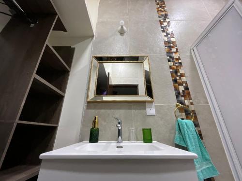un baño con lavabo y espejo en Villa Encanto Costero, en Monte Gordo