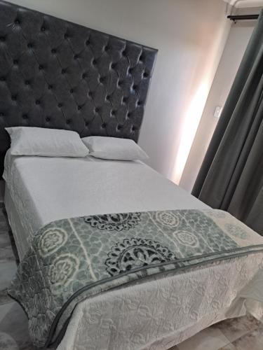 a bedroom with a bed with a black headboard at Randhart guesthouse in Alberton