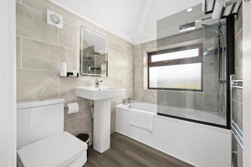 a bathroom with a toilet and a sink and a tub at 52 Furnival Road, Manchester in Manchester