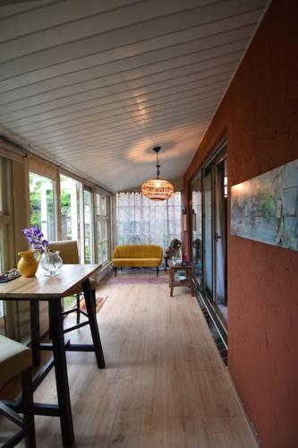 a living room with a table and a yellow couch at Indigena Forest Retreat -Entire 6 persons Family home near Efteling and Dunes in Sprang-Capelle
