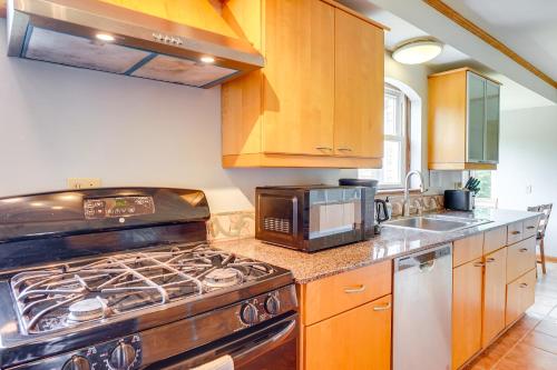 a kitchen with a stove and a microwave at Pet-Friendly New Berlin Retreat with Patio and Yard! in New Berlin