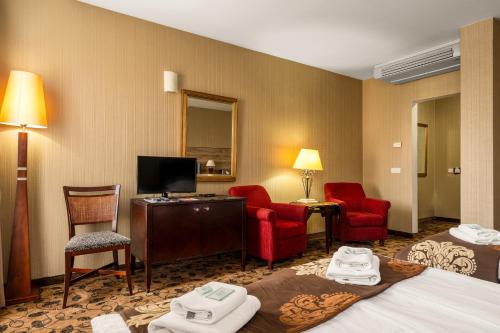 een hotelkamer met 2 bedden en 2 stoelen bij Great Polonia Kraków Kazimierz in Krakau