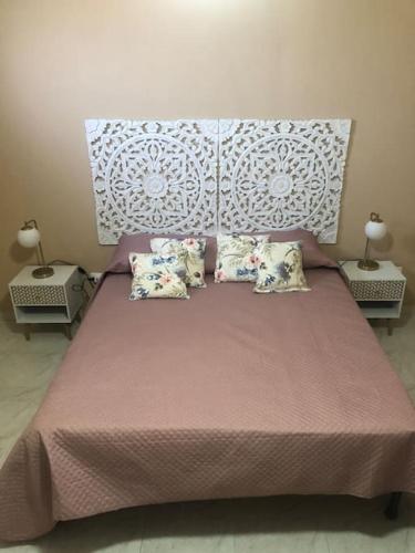 a bedroom with a large bed with pink sheets and pillows at CasaLotto in Reggio Calabria