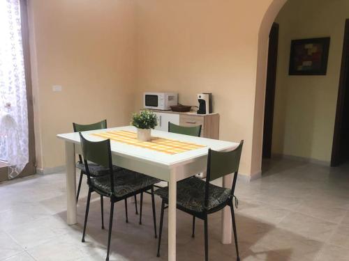 a dining room table with chairs and a white table with at CasaLotto in Reggio Calabria