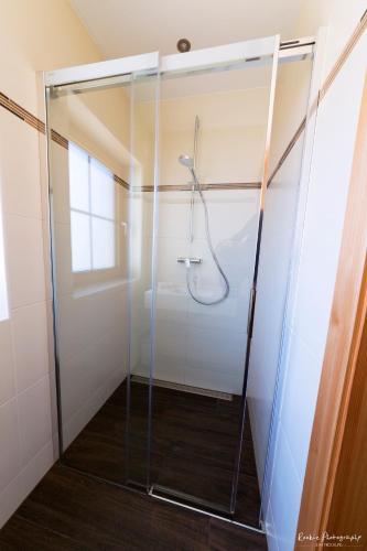 a shower with a glass door in a bathroom at Feriengut Linortner in St. Wolfgang