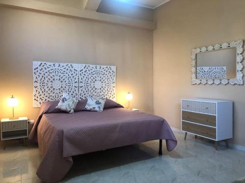 a bedroom with a bed and two lamps and a mirror at CasaLotto in Reggio Calabria