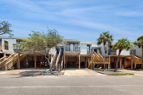 a building with stairs and palm trees in a parking lot at Ocean Mile L7 Gulf Beach Getaway in St. George Island