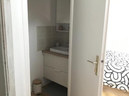a small white bathroom with a sink and a counter at Appartement idéalement situé in Les Sables-dʼOlonne