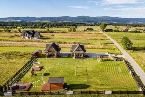 an aerial view of a farm with houses and a field at DOMKI TATRY z jacuzzi i sauną w cenie - spokojna okolica - świetna dla rodzin z dziećmi lub grupy znajomych! in Szaflary
