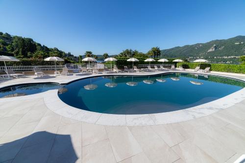 a large swimming pool with chairs and umbrellas at Hotel La Bussola in Orta San Giulio