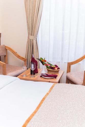 a bedroom with a table with a glass of wine at Temple Himalaya Hotel & Spa in Pokhara