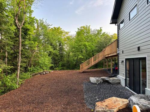 an empty driveway next to a house with a deck at Whispering Pines Muskoka 3BR 3 Ensuite Baths in Dwight