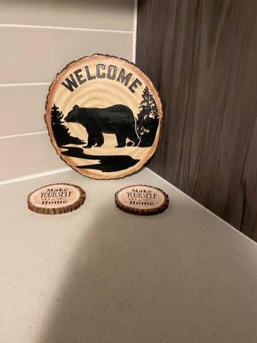 a welcome sign with a black bear on a counter at Whispering Pines Muskoka 3BR 3 Ensuite Baths in Dwight