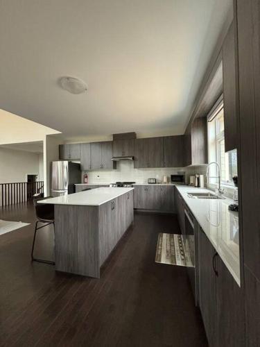 a large kitchen with wooden cabinets and a large island at Whispering Pines Muskoka 3BR 3 Ensuite Baths in Dwight