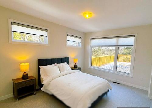 A bed or beds in a room at Whispering Pines Muskoka 3BR 3 Ensuite Baths