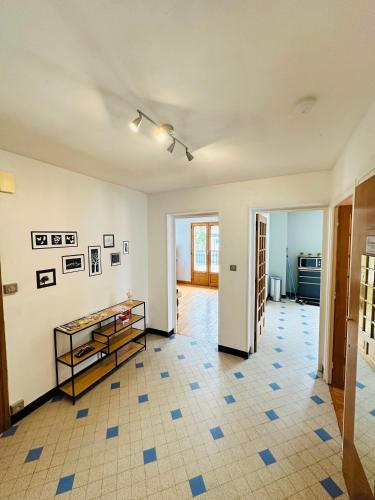 Elle comprend un salon doté de carrelage et de murs blancs. dans l'établissement Appart 4 pers Grande terrasse vue sur montagne, à Saint-Jean-de-Maurienne