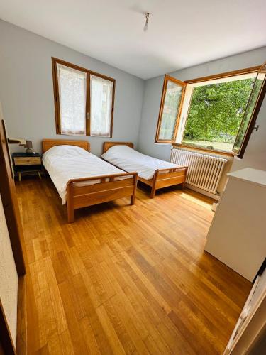 une chambre avec deux lits et une grande fenêtre dans l'établissement Appart 4 pers Grande terrasse vue sur montagne, à Saint-Jean-de-Maurienne