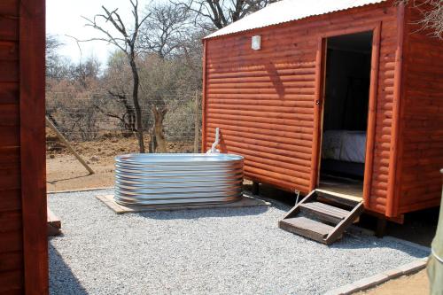 a wooden cabin with a large tub in front of it at Thirty-Three Dinokeng Big 5 in Klipdrift