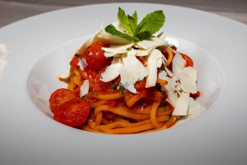 a plate of pasta with tomato sauce and cheese at Hotel La Bussola in Orta San Giulio