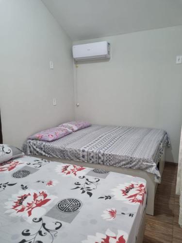 two twin beds in a room with avertisement for at Kamke's Haus III in Pomerode