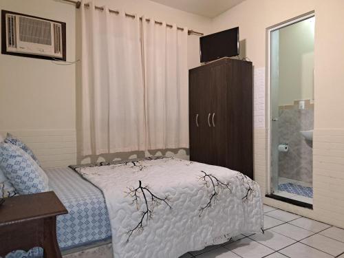 a bedroom with a bed and a dresser with a television at Aeropouso Pousada Executiva in Florianópolis