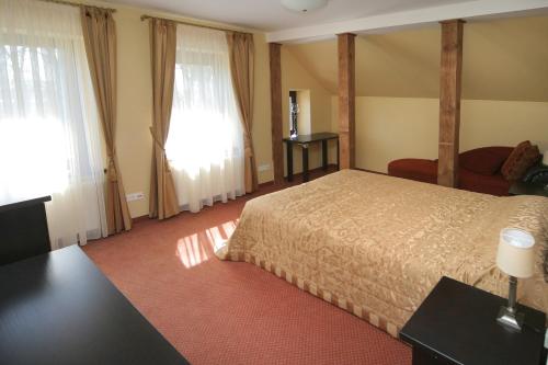 a hotel room with a bed and two windows at Grafo Zubovo Hotel & SPA in Bubiai