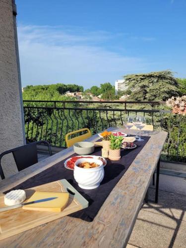 - une table en bois avec de la nourriture sur le balcon dans l'établissement Mini Penthouse, à Avignon