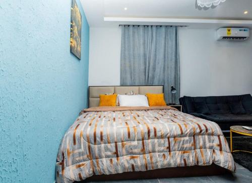a bedroom with a bed and a blue wall at Stay with Peace on Spintex road in Baatsona