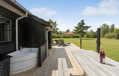 a bath tub sitting on a wooden deck at Cozy Home In Væggerløse With Wifi in Marielyst