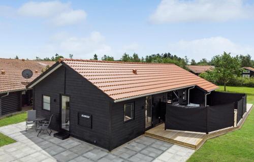 a black tiny house with a red roof at Cozy Home In Væggerløse With Wifi in Marielyst